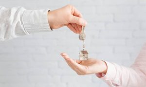 Manos de personas pasándose llaves de una propiedad, representando los sitios donde encontrar casa o departamento en México