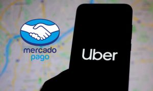 Un celular con el logo de Uber en su pantalla, y de fondo apreciamos un mapa digital con trazos de calles, además de ver el logo de Mercado Pago a un costado.