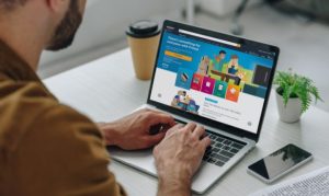Plano escorzo de un hombre accediendo a Amazon desde su laptop, aprovechando la nueva solución de pagos quincenales.