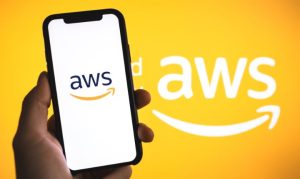 Plano detalle de una mano sosteniendo un celular con el logo de Amazon Web Services, y de fondo el logotipo de la filial.