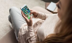 Chica accediendo a apps de entretenimiento y música desde su smartphone.