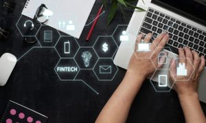 Toma cenital de una usuaria accediendo a su banca digital desde su laptop. Vemos íconos relacionados al ecosistema fintech, en referencia a Bineo, la nueva fintech de Banorte.