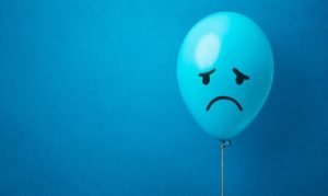 Un globo azul con cara triste, y al fondo una textura azul; esto en referencia al Blue Monday, el día más triste del año y temporalidad aprovechada en marketing.