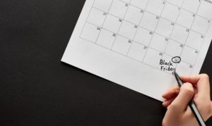 Una mano encerrando con un plumón la fecha del 29 de noviembre en un calendario, en referencia al Black Friday y a las fechas importantes para campañas comerciales en eCommerce y marketing.