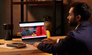 Mockup de un hombre sentado en su escritorio mirando su laptop, la cual muestra el eCommerce de Champion en México.