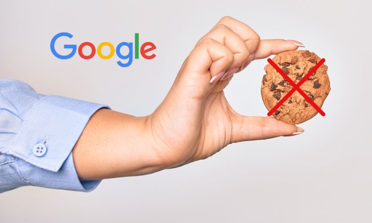 una mano sostiene una cookie tachada con una cruz roja, en señal del fin de las cookies implementada por Google