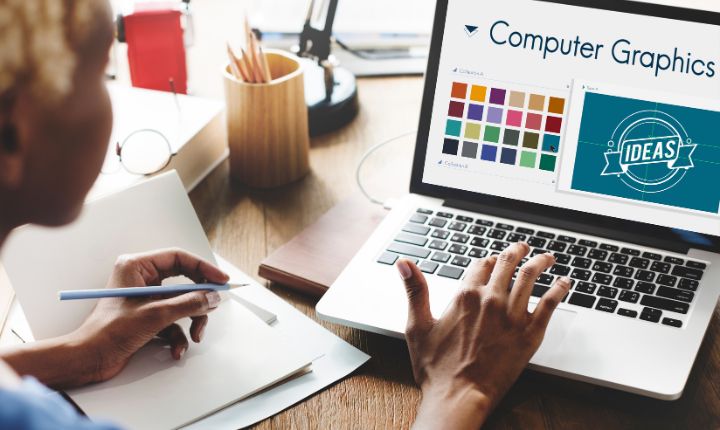 Chica haciendo una infografía de marketing desde su computadora, en la que se aprecian recursos gráficos, paletas de colores y demás.