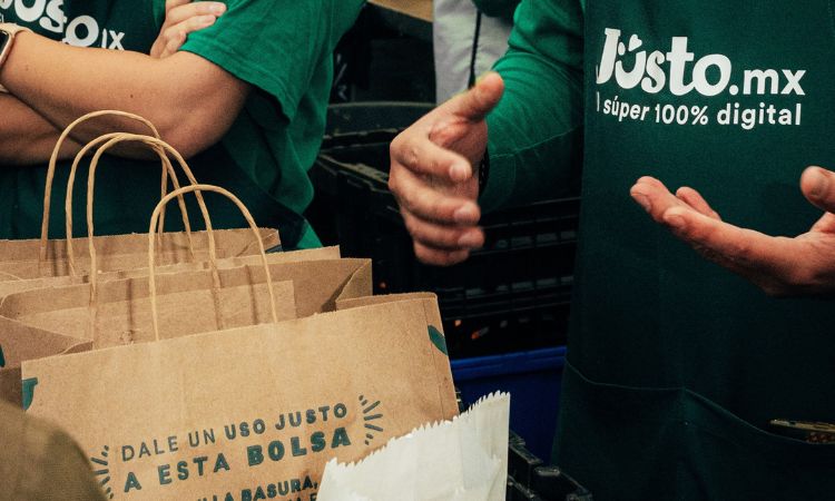 Plano medio de colaboradores Jüsto en México entregando pedidos en los hogares mexicanos.