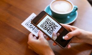 manos que detienen un móvil y un código QR donde se escanea mostrando el funcionamiento de los códigos QR de Mercado Pago en México