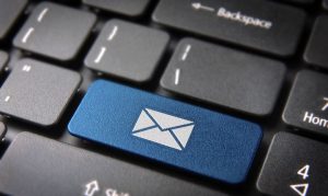 Un teclado de una computadora mostrando una tecla con el ícono de un correo; esto en referencia a los pasos del email marketing.