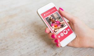 Una usuaria estableciendo contacto con un perfil falso en apps de citas. La vemos sosteniendo su celular y en la pantalla la interfaz de la dating app.