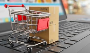 Un carrito de compras y una caja de pedido encima del escritorio de una laptop; esto en referencia al crecimiento de las plataformas chinas de eCommerce en México.