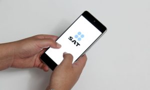 Plano picado de un usuario accediendo a su app del SAT desde su celular; esto en referencia a la fiscalización de apps de eCommerce en México de cara al 2024.
