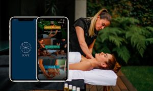 Representación gráfico del servicio de Scape a domicilio. Vemos a una masajista atendiendo a una chica recostada y disfrutando de su masaje. A un lado, vemos sobrepuesto un mockup de celulares con la aplicación abierta.