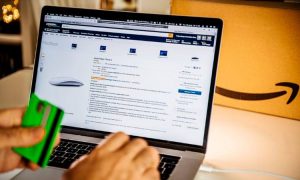 Manos de hombre en una laptop abierta con la página de Amazon activa mostrando como los ads pueden impulsar las ventas durante El Buen Fin