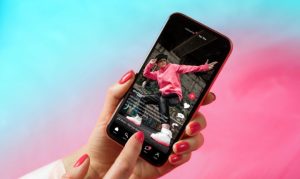 Una usuaria sosteniendo su celular, en el cual vemos la app de TikTok. Esto en referencia al taller de uso de TikTok para PyMES en México.