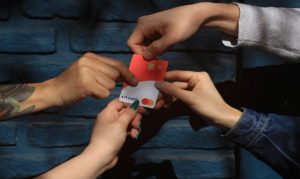 4 personas sosteniendo una tarjeta bancaria de Ualá, fintech argentina.