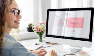 Mujer viendo monitor con un sitio web que representa cómo comenzar a vender online